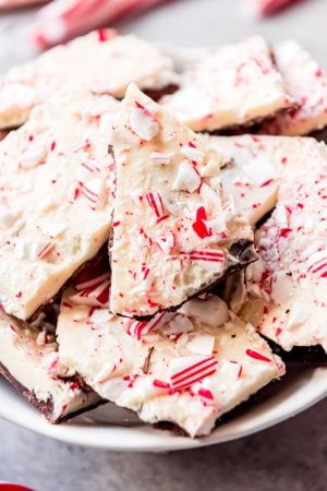 A close-up image of crushed candy canes on white and dark chocolate peppermint bark.