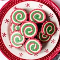 An image of Christmas pinwheel cookies on a festive red and white holiday plate.