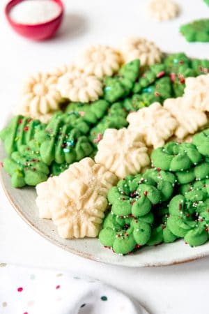 An image of classic Spritz cookies piled on a plate together.