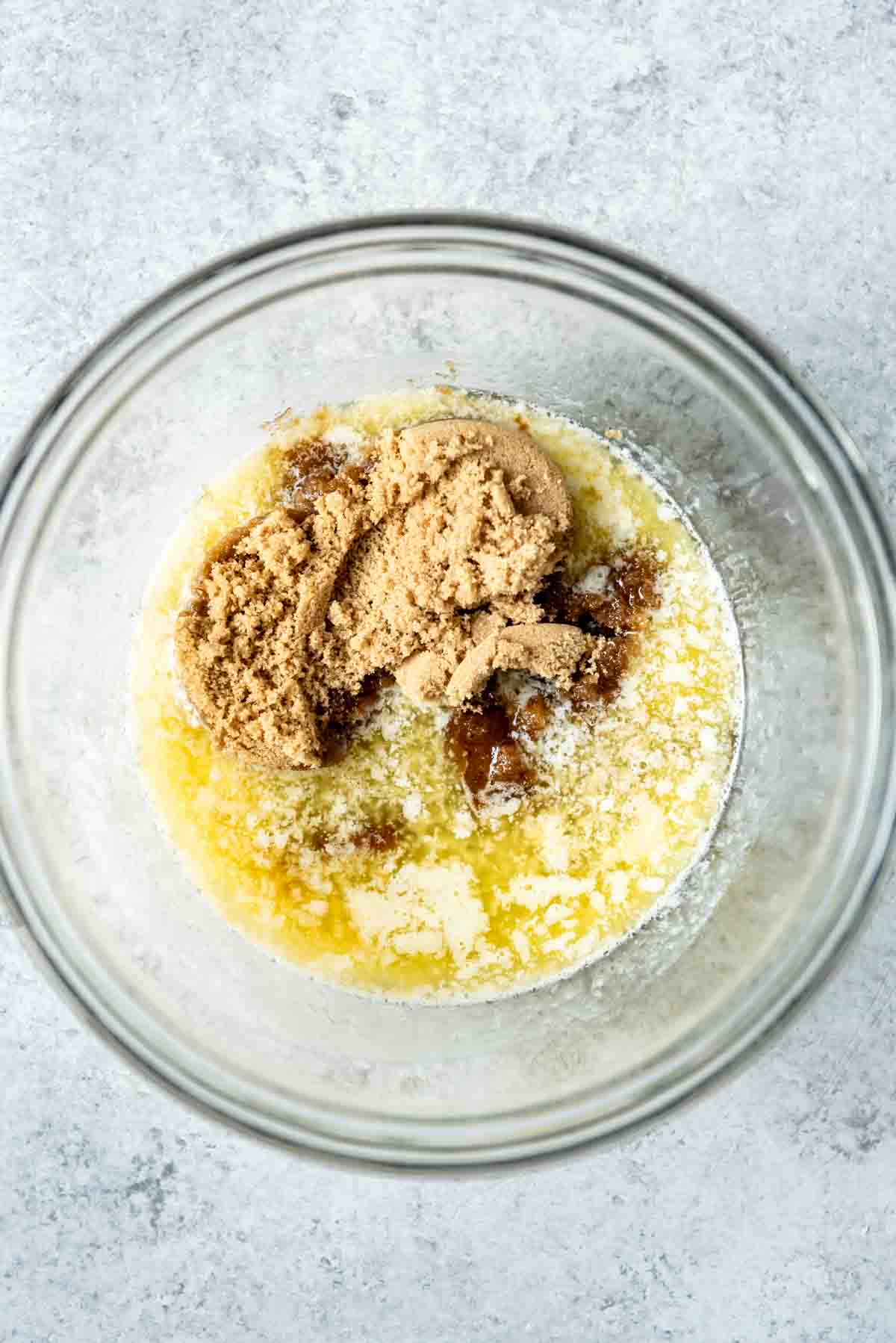 Combining melted butter and brown sugar in a bowl.