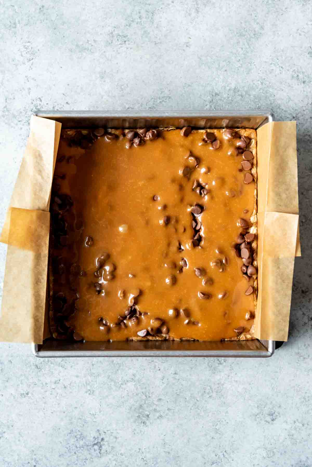 Caramel drizzled over chocolate chips and an oat crust.