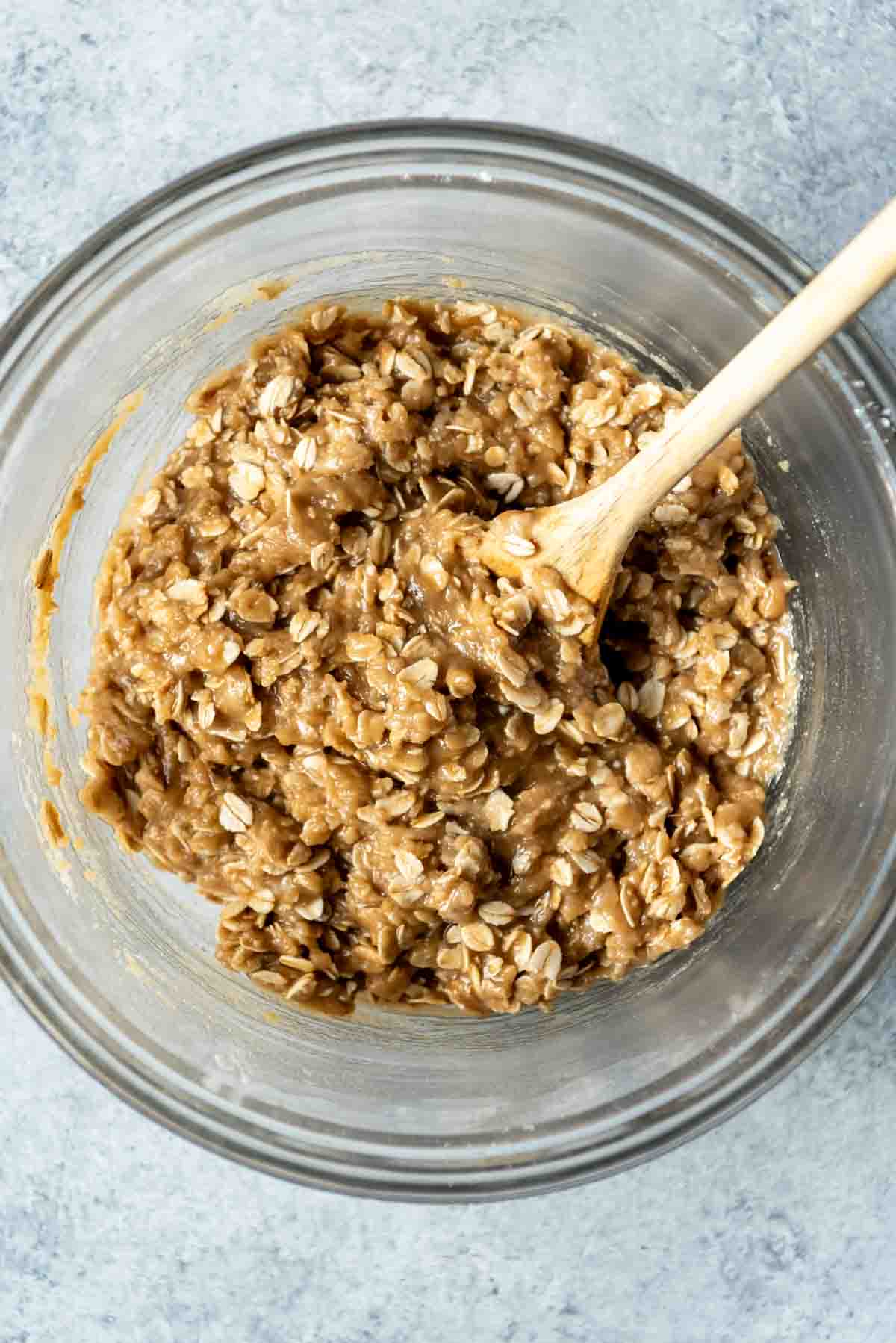 Combining oatmeal cookie dough in a bowl.