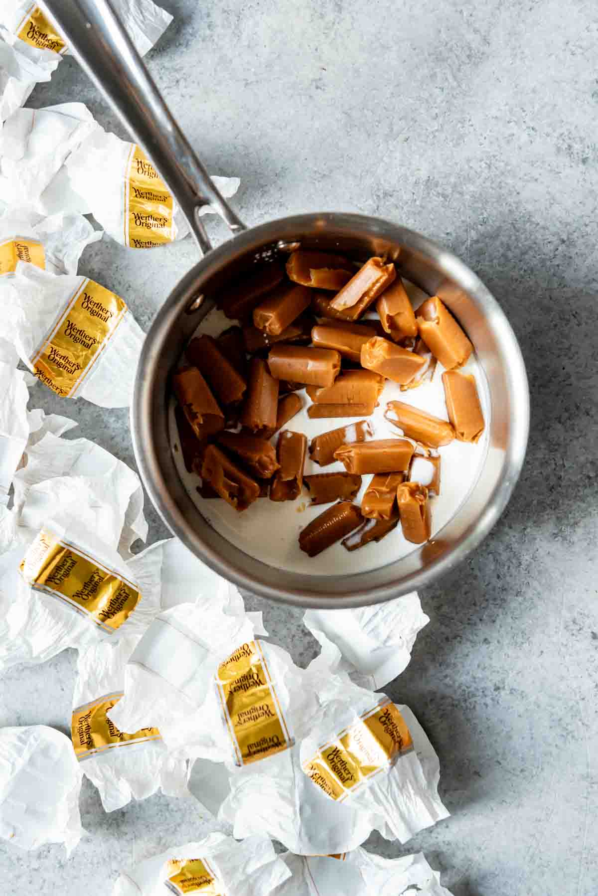 An image of unwrapped Werther's original chewy caramels in a saucepan with cream.