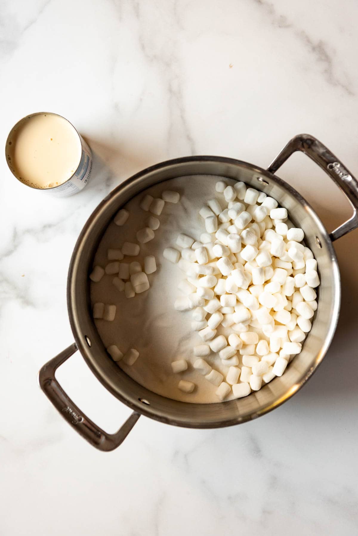 An image of a large pot with sugar, marshmallows, and evaporated milk.