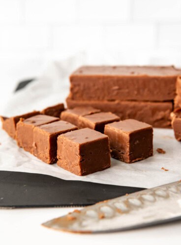 An image of creamy chocolate fudge cut into squares for serving.