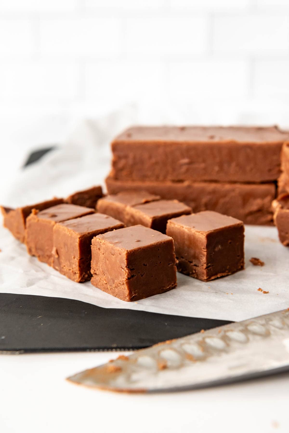 An image of creamy chocolate fudge cut into squares for serving.