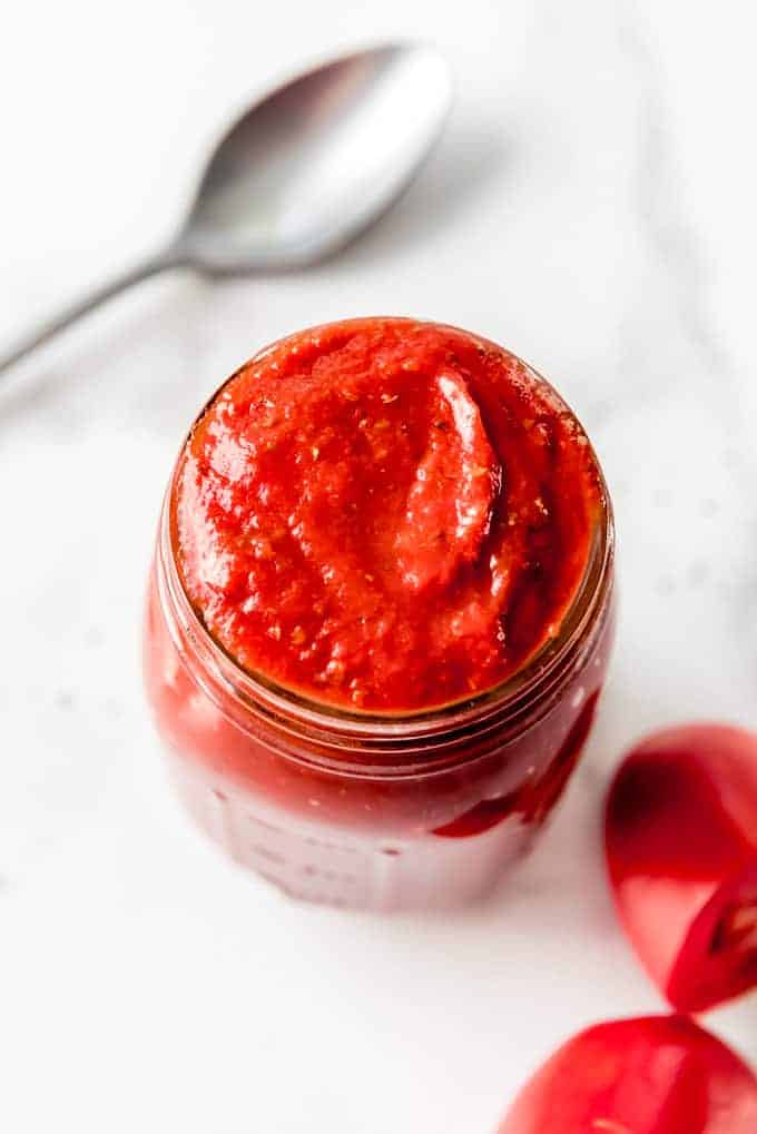 An image of a rich, thick homemade pizza sauce in a jar.