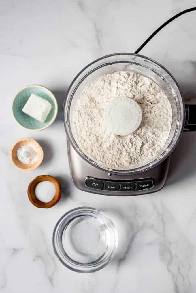 An image of the ingredients for making tortillas using a food processor.