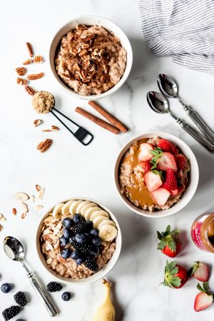 An image of three bowls of oatmeal with different toppings.