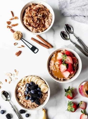 An image of three bowls of oatmeal with different toppings.