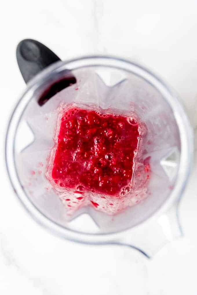 An image of thawed frozen raspberries in a blender.
