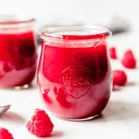 An image of raspberry coulis sauce in glass Weck jars.