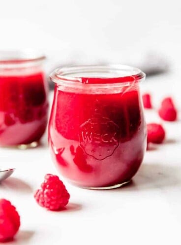 An image of raspberry coulis sauce in glass Weck jars.