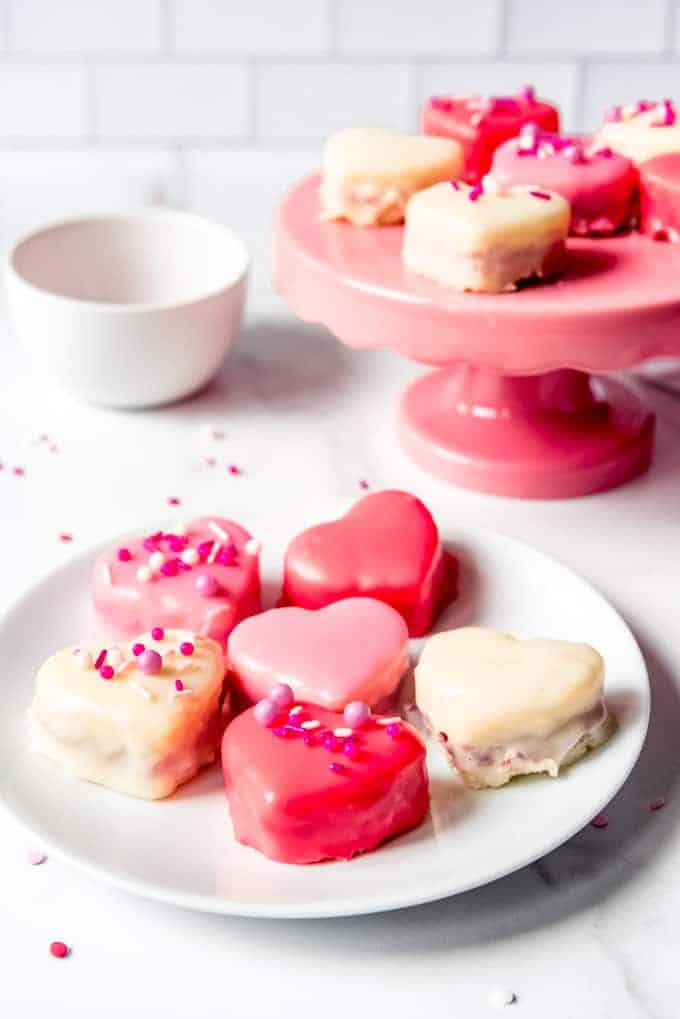 An image of red, white, and pink Valentine's Day petit four cakes on a plate.