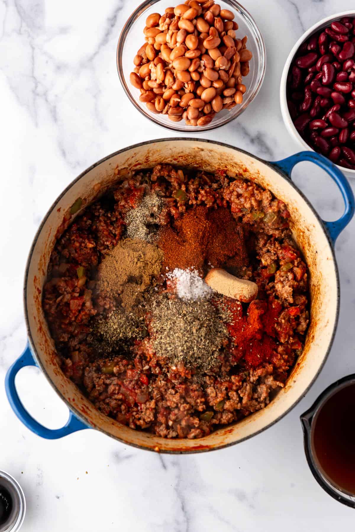 Adding spices to make chili.