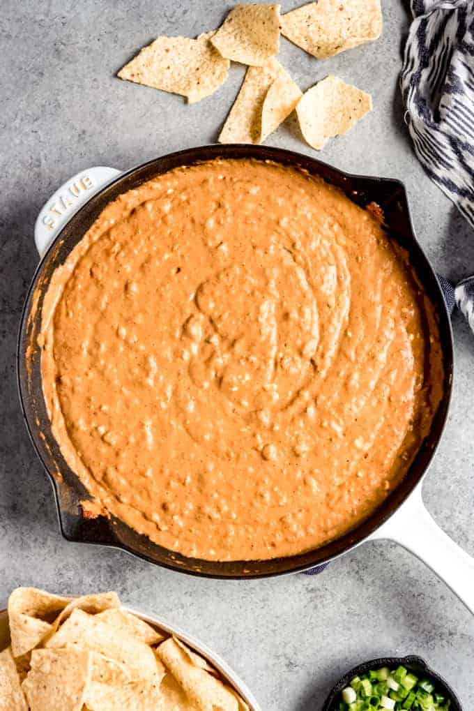 An image of a cheesy bean dip recipe made in a cast iron skillet.