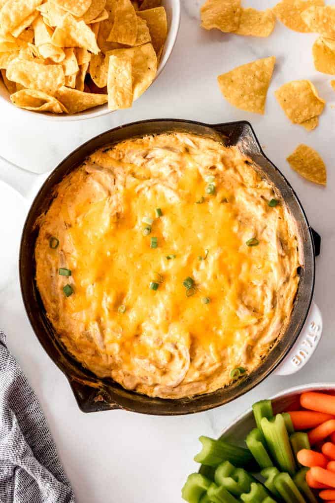 a skillet full of buffalo chicken dip topped with melted cheese