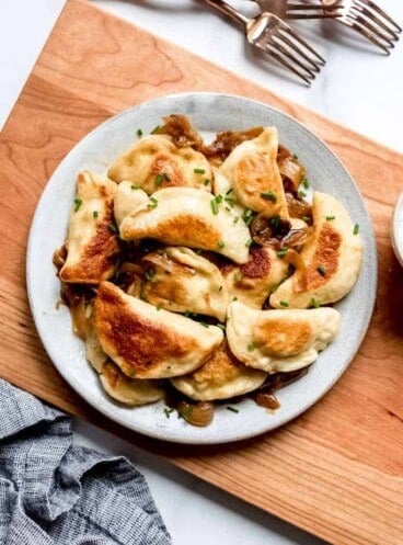 An overhead visual of a plate filled with crispy golden pierogi