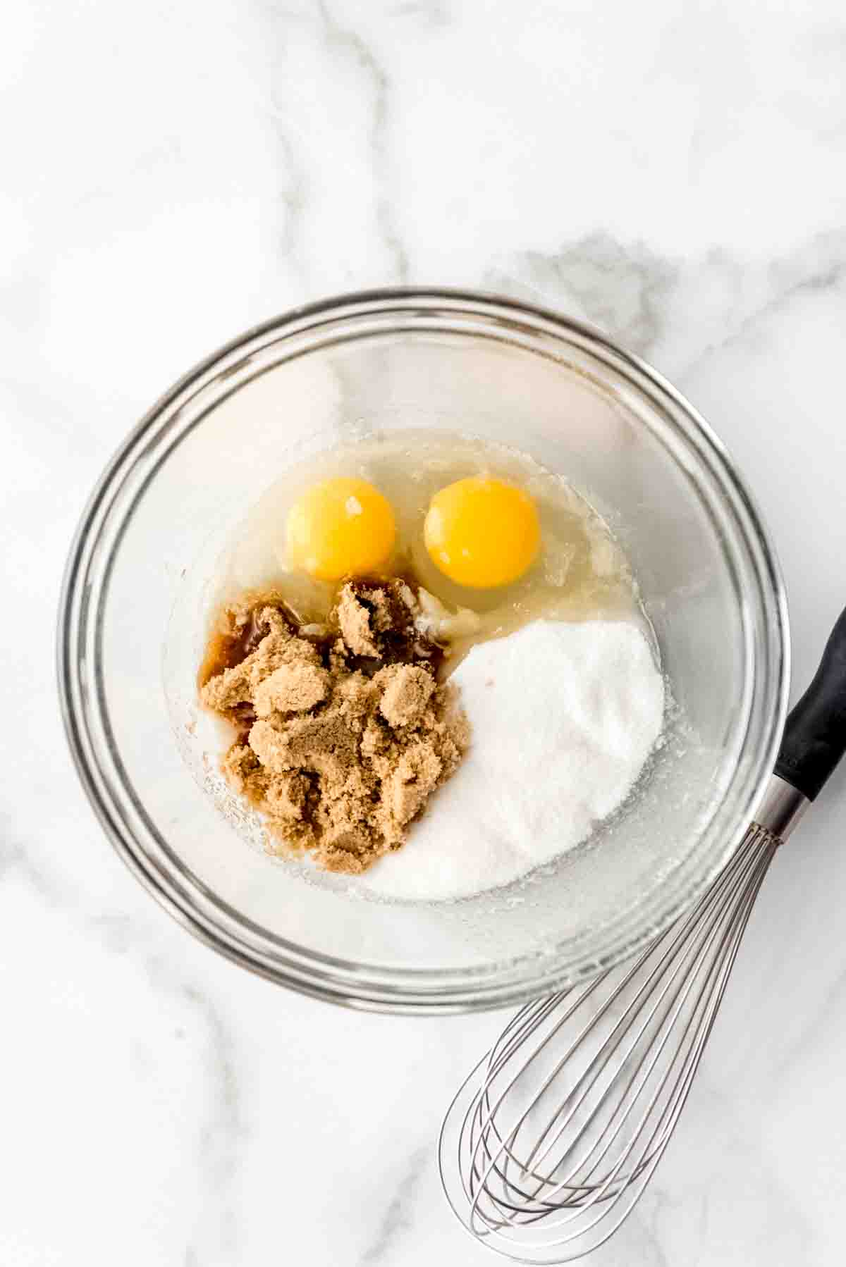 Combining eggs, sugar, and nutella in a bowl.