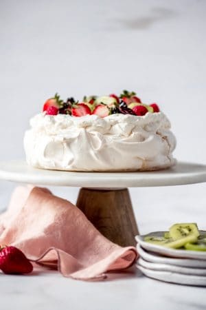 An image of a classic pavlova on a cake stand.