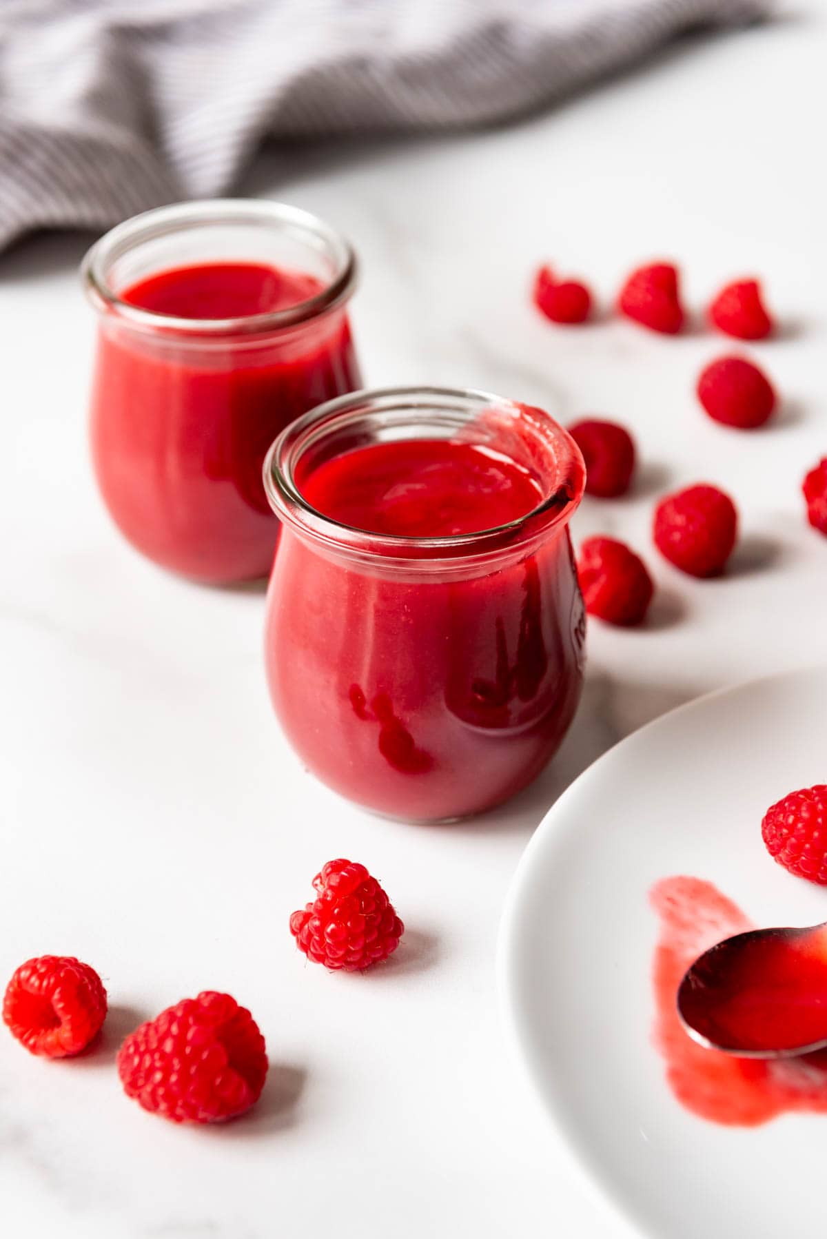 An image of a dessert fruit sauce in glass jars.