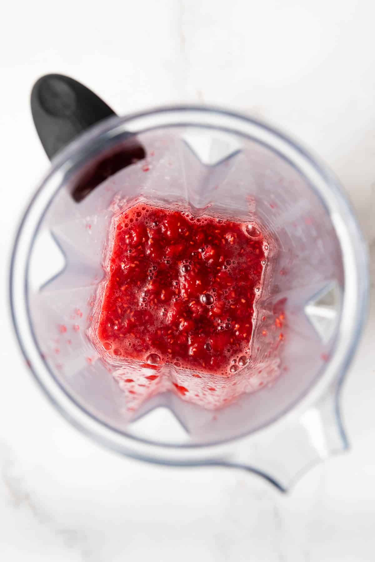 An image of thawed frozen raspberries in a blender.