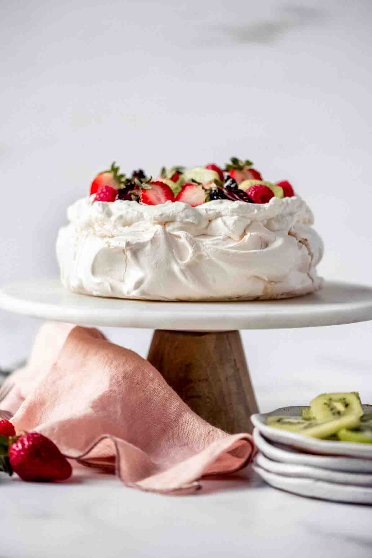 An image of a classic pavlova on a cake stand.