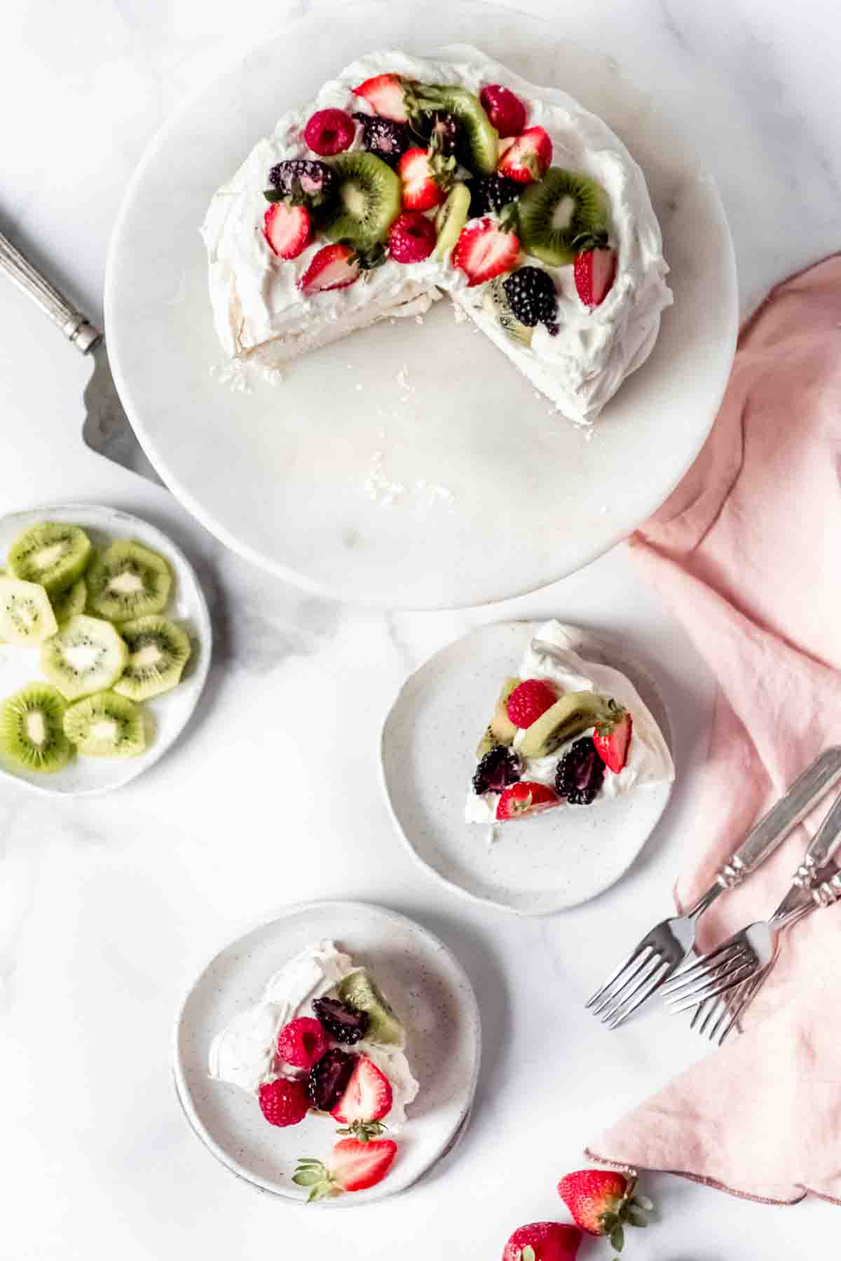 An image of slices of homemade pavlova on dessert plates.