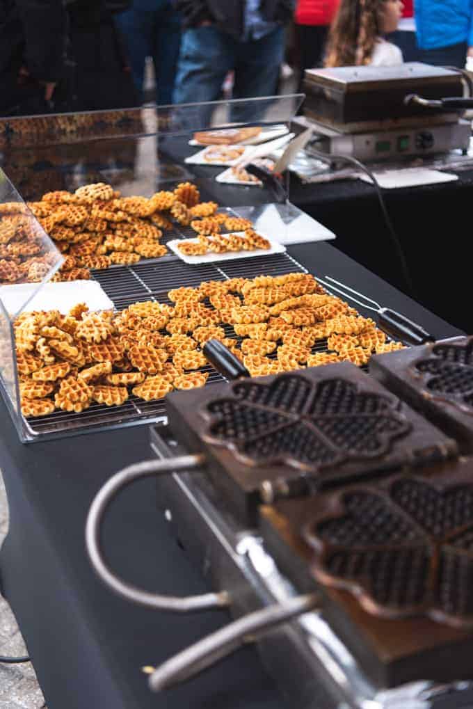 An image of waffle cookies being made at a market in Belgium.