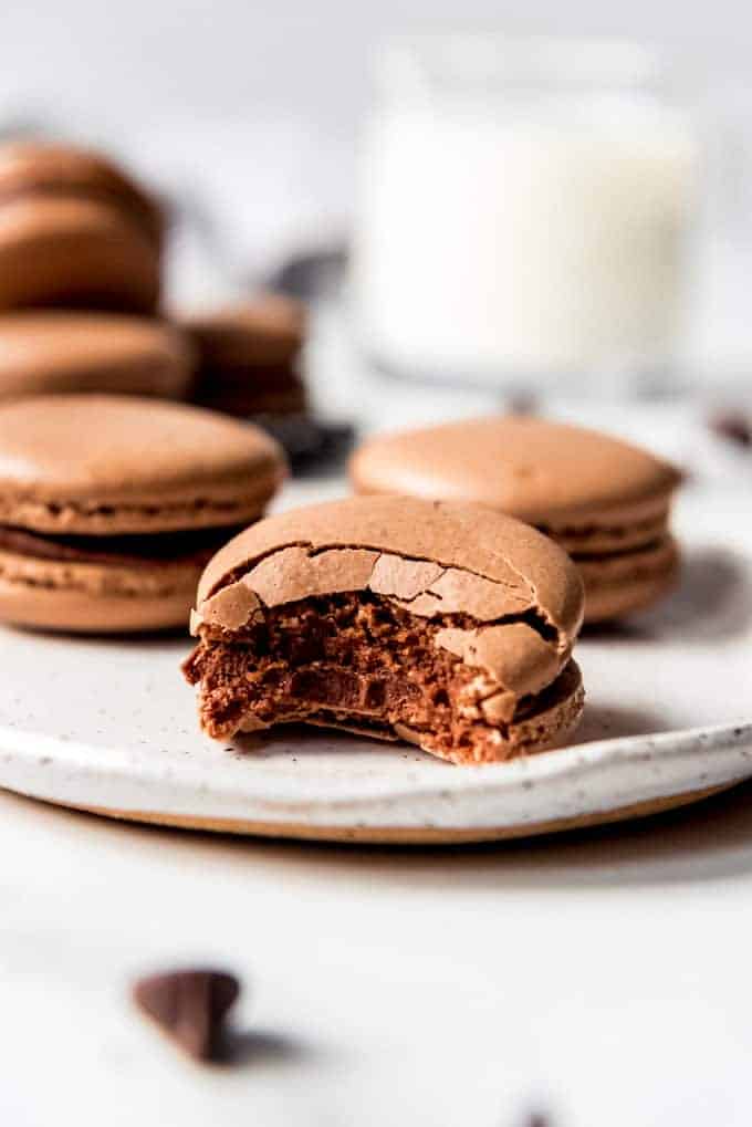 An image of a homemade chocolate macaron cookie with chocolate ganache filling.