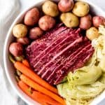 An image of a large plate of sliced corned beef and cabbage with potatoes and carrots.