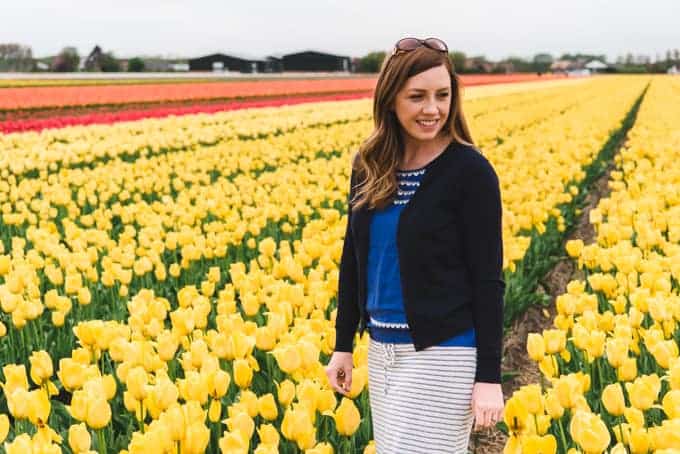 An image of a woman in a field of yellow tulips.