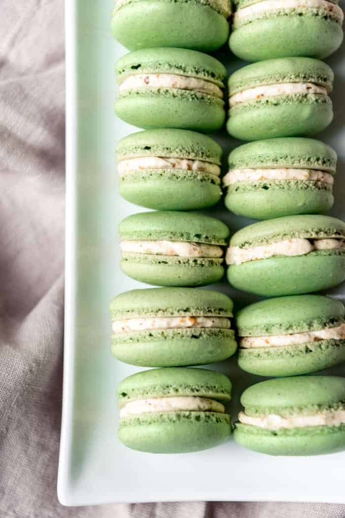 An image of green french macarons arranged on a plate.