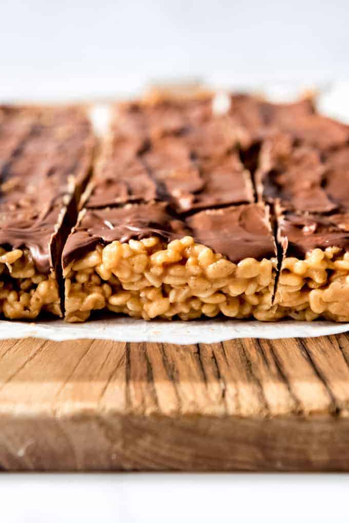 A side view of chewy peanut butter rice krispie treats with butterscotch chocolate topping.
