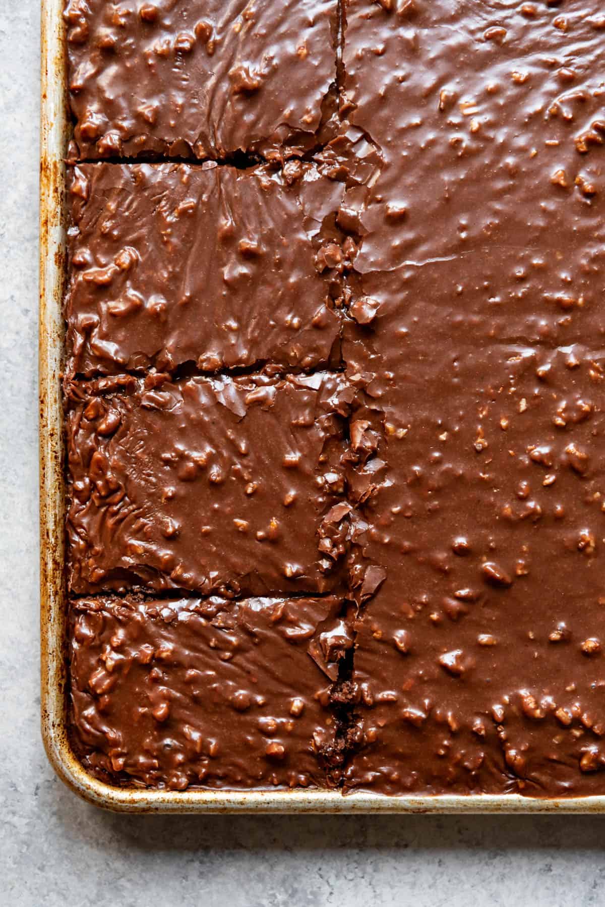 An image of a sliced Texas sheet cake with pecans.