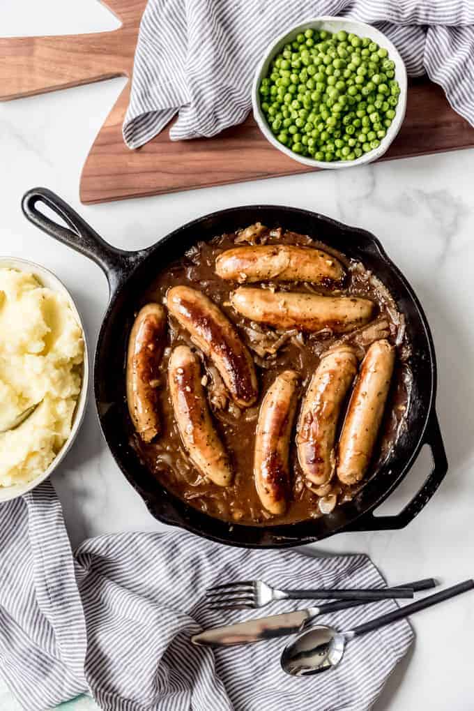 An image of a pan of bangers in onion gravy.