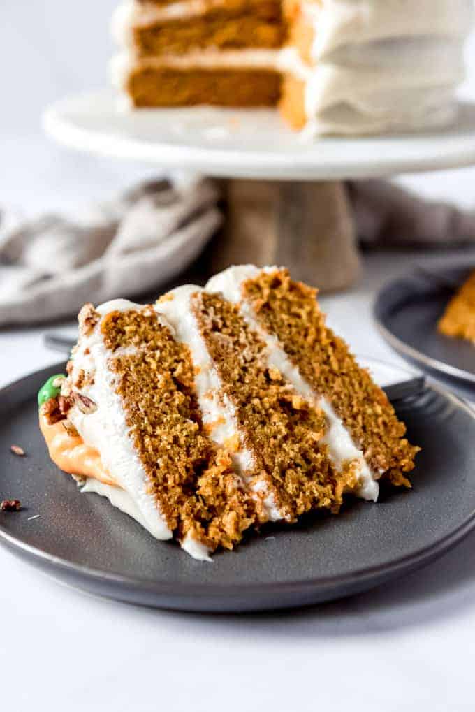 An image of a slice of moist homemade carrot cake on a plate.