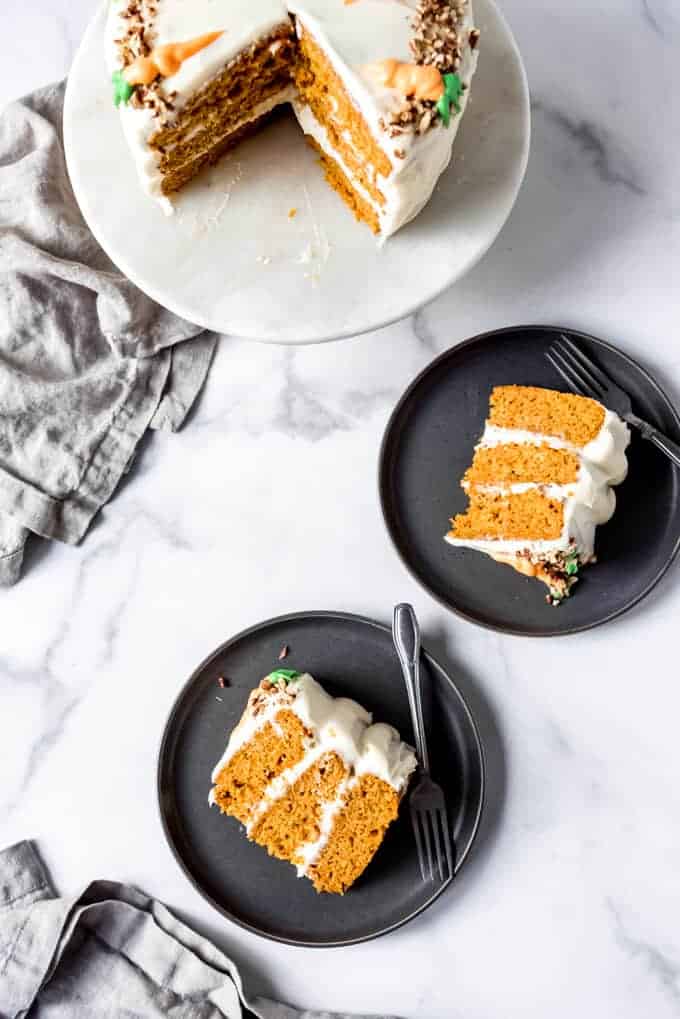 An image of slices of carrot cake on plates with forks.