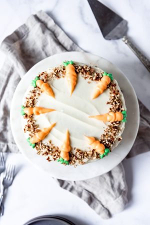 An image looking down onto the top of a carrot cake decorated with piped carrots made from frosting.