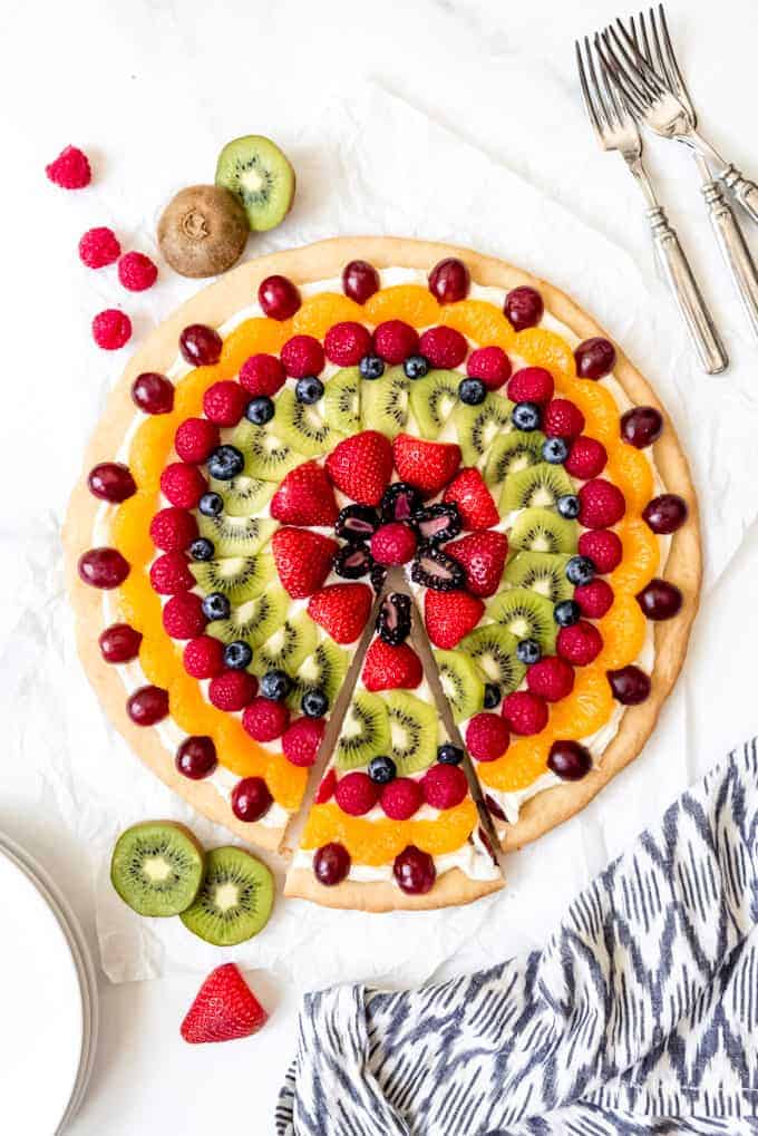 An image of a fruit pizza with one slice removed.