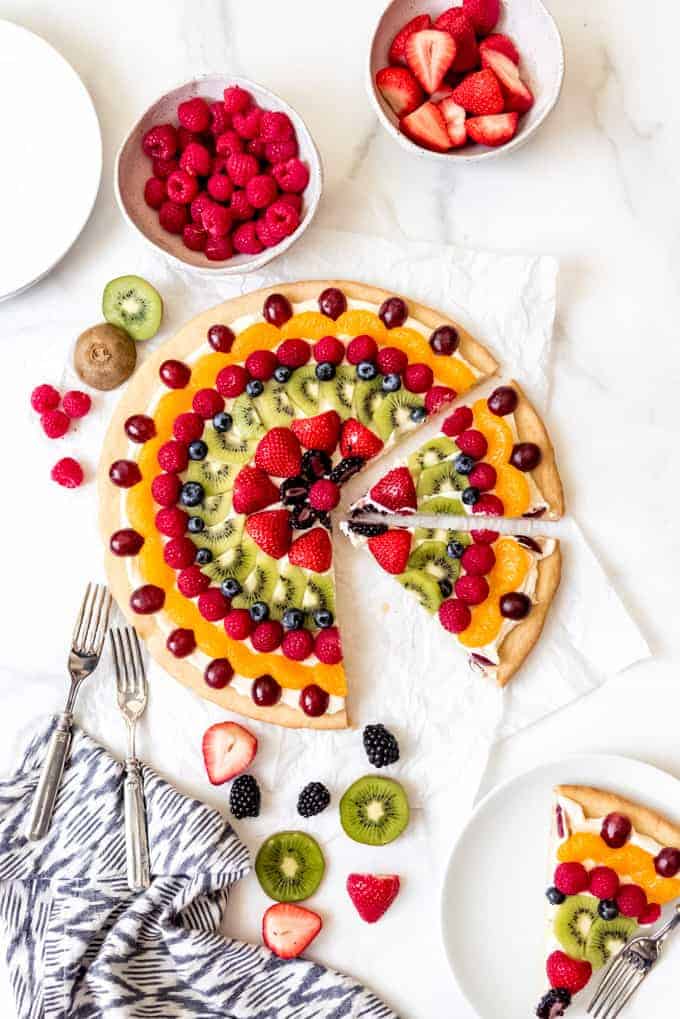 An image of a homemade fruit pizza sliced into wedges to serve.