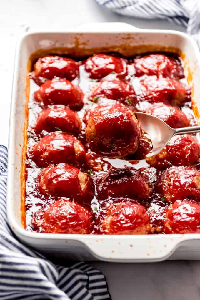 An image of a large baking dish full of Iowa ham balls in a sweet and sour sauce.