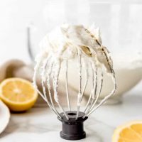 An image of a kitchenaid whisk attachment covered in homemade lemon buttercream frosting.