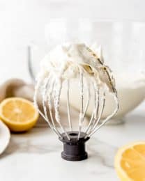 An image of a kitchenaid whisk attachment covered in homemade lemon buttercream frosting.