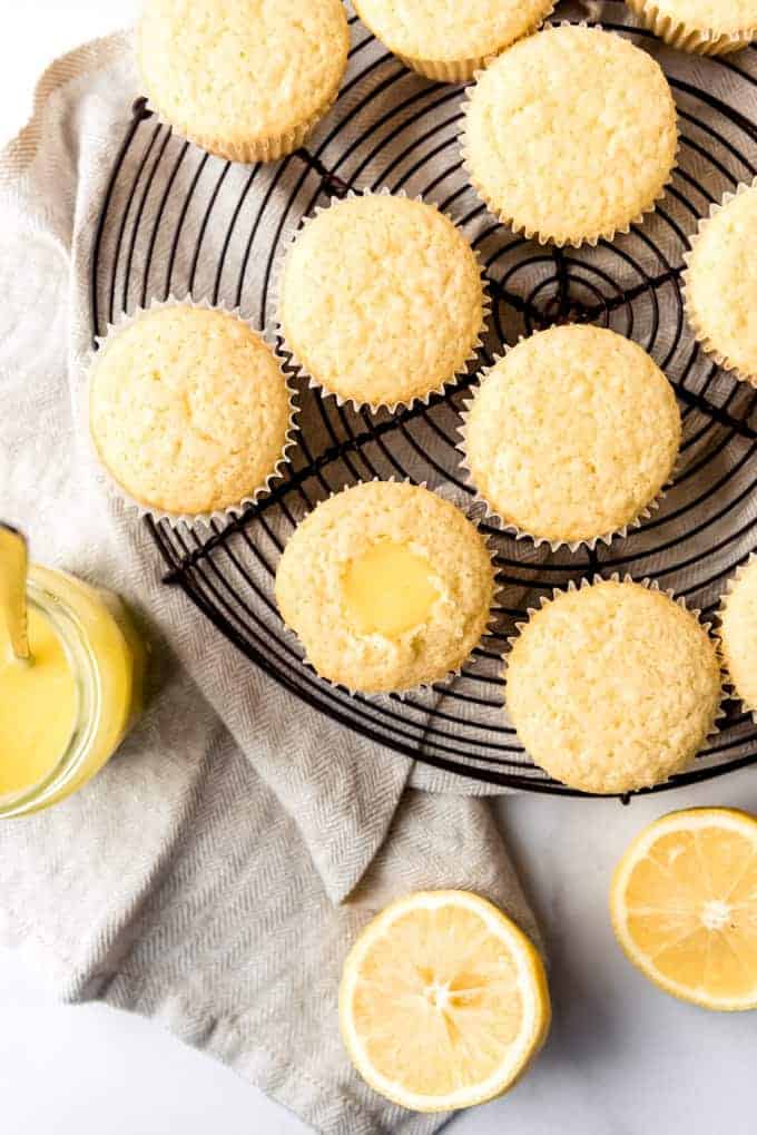 An image of unfrosted cupcakes being filled with homemade lemon curd filling.