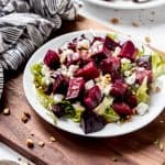 An image of roasted beet salad with goat cheese and pistachios on a plate.