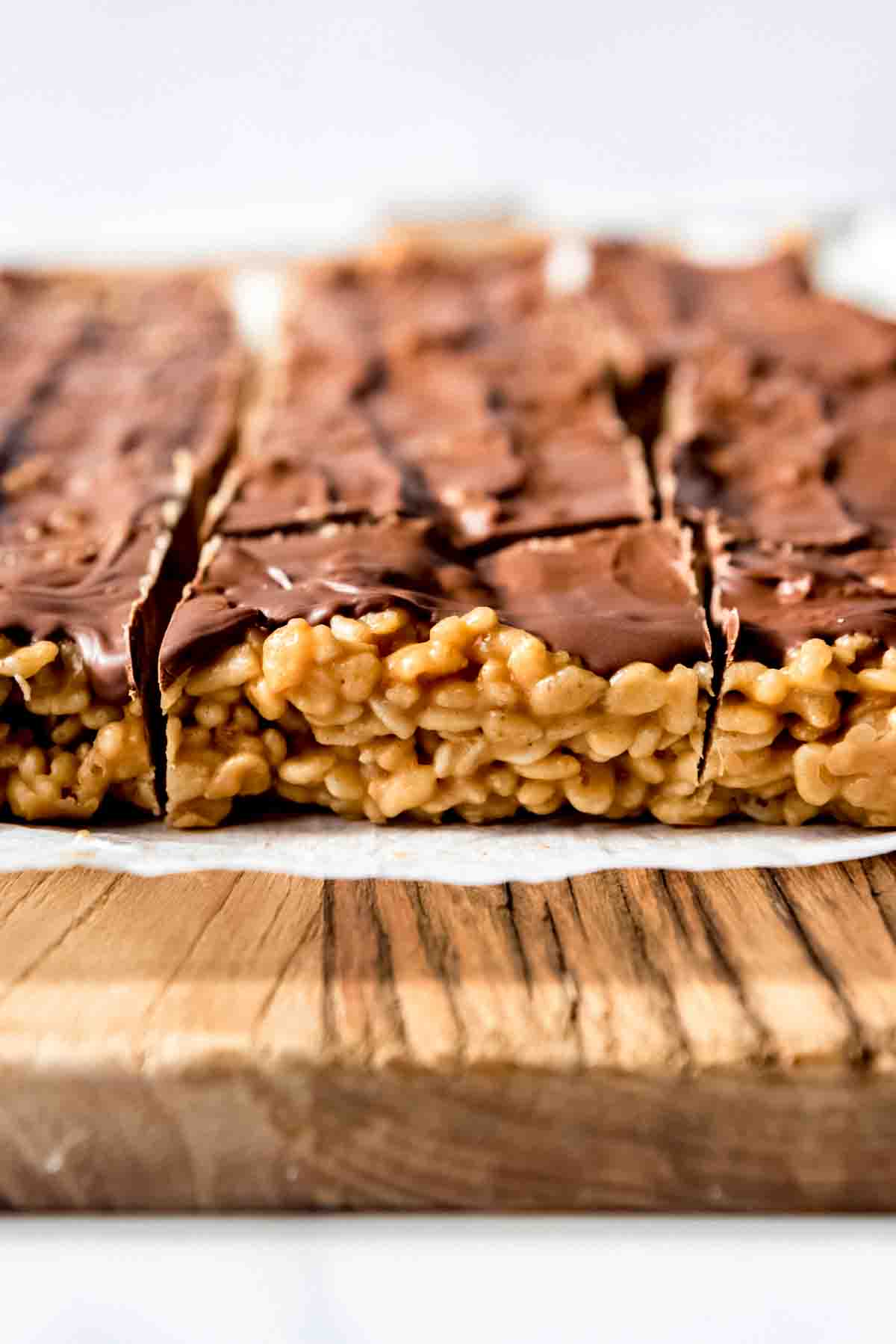 A side view of chewy peanut butter rice krispie treats with butterscotch chocolate topping.