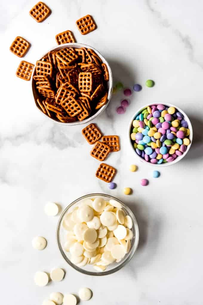 An image of bowls of butter snap pretzels, Easter M&M's, and Ghiradelli white chocolate melting wafers candy melts.