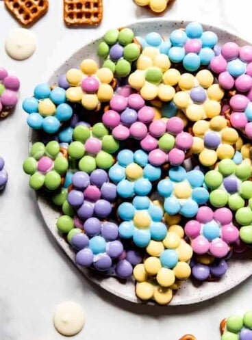 An image of Easter flower pretzel bites in pastel colors on a plate.