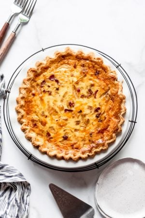 An image of a bacon and cheese quiche on a cooling rack.